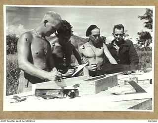 RAMU VALLEY, NEW GUINEA. 1943-12-21. CARPENTERS OF THE 53RD AUSTRALIAN FIELD PARK COMPANY, ROYAL AUSTRALIAN ENGINEERS, 7TH AUSTRALIAN DIVISION WORKING ON THE CONSTRUCTION OF A NEW UNIT HUT. THEY ..