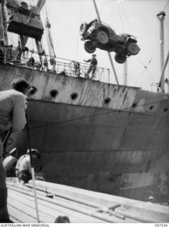 NEW GUINEA. 1943-07-24. UNLOADING A JEEP FROM THE M.V. "DUNTROON" ONTO THE DOCKS. AT THE EXTREME LEFT CAN BE SEEN SERGEANT MCKECKNIE, PHOTOGRAPHER, MILITARY HISTORY SECTION