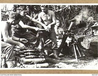 SHAGGY RIDGE, NEW GUINEA. 1943-12-27. MEMBERS OF A 3 INCH MORTAR CREW OF THE 2/16TH AUSTRALIAN INFANTRY BATTALION, 21ST AUSTRALIAN INFANTRY BRIGADE IN ACTION BOMBARDING THE "PIMPLE" PRIOR TO THE ..