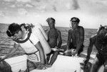 Divers, including Walter Munk (left center) and Robert Livingston (right center), work from a motor launch at Alexa Bank, Samoa