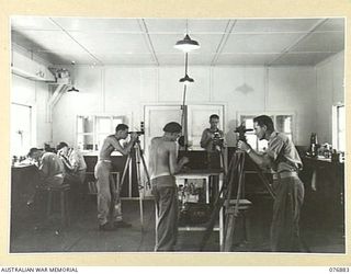 LAE AREA, NEW GUINEA. 1944-11-15. INSTRUMENT MAKERS WORKING ON CAMERAS AND THEODOLITES IN THE INSTRUMENT SECTION OF THE 2/7TH ADVANCED WORKSHOPS