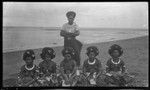 Motu women, some wearing kina, crescent shell valuable necklace, and Ahuia (Lambert's assistant) behind