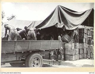 RABAUL, NEW BRITAIN. 1945-09-25. A JAPANESE WORKING PARTY UNLOADING CASES OF BEER WHICH WILL BE ISSUED TO AUSTRALIAN TROOPS FROM THE AUSTRALIAN ARMY CANTEENS SERVICE ISSUING POINT IN A FEW DAYS