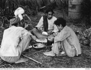 WEWAK AREA, NEW GUINEA, 1945-05-23. INDIAN SOLDIERS WHO ESCAPED FROM JAPANESE CAPTIVITY, ENJOYING A SOLID MEAL PROVIDED BY 2/8 INFANTRY BATTALION