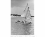 Unidentified man on a boat showing a Rongelap Atoll beach in the background, summer 1964