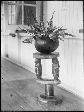 New Guinea flowers in a round bowl on a Trobriand Island stool, Rabaul, New Guinea, ca. 1929 / Sarah Chinnery