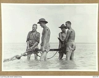 MIRAVASI (MINVASI?), NEW GUINEA. 1943-06-29. CLOSE-UP OF ANCHORING PARTY TETHERING PILE- DRIVER BARGES OF THE 2/4TH AUSTRALIAN FIELD SQUADRON, ROYAL AUSTRALIAN ENGINEERS. LEFT TO RIGHT:- WX17388 ..