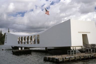 A view of the USS ARIZONA Memorial which spans the sunken hulk of the battleship ARIZONA (BB 39). The battleship was sunk in the opening minutes of World War II during the Japanese attack on the harbor. Over 1000 men are entombed in the vessel's hull, which is now a national cemetery