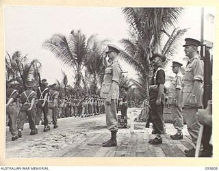 JACQUINOT BAY, NEW BRITAIN, 1945-07-01. HIS ROYAL HIGHNESS, THE DUKE OF GLOUCESTER, GOVERNOR-GENERAL OF AUSTRALIA (1), TAKING THE SALUTE FROM TROOPS OF 29/46 INFANTRY BATTALION DURING THE MARCH ..