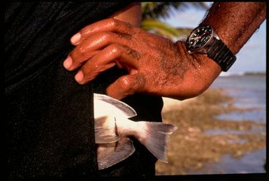 Man with fish in pocket, Rakahanga, Cook Islands