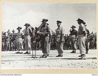 CAPE WOM, NEW GUINEA, 1945-09-13. MAJOR D.S.I. BURROWS, DEPUTY ASSISTANT ADJUTANT GENERAL, 6 DIVISION, ADDRESSING TROOPS OF 6 DIVISION, DURING THE SURRENDER CEREMONY HELD AT CAPE WOM AIRSTRIP. ..