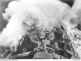 At sea. 1942. Waves crash over the bow of HMAS Adelaide as she ploughs through a large swell, while on patrol and escort duties in northern Australia and New Guinea. This elevated view of the deck ..