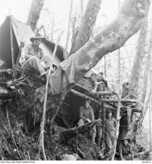 SHAGGY RIDGE, NEW GUINEA. 1944-01-20. MEMBERS OF THE MORTAR DETACHMENT OF THE 2/9TH INFANTRY BATTALION IN FRONT OF THEIR 2 STOREY BUNKS ON A STEEP HILLSIDE. IDENTIFIED PERSONNEL ARE: QX36098 ..