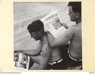 WIRUI BEACH, WEWAK AREA, NEW GUINEA. 1945-09-05. PRIVATE C.R. RICE (1), AND PRIVATE H.W. BIGNELL (2), MEMBERS OF 2/11 INFANTRY BATTALION SITTING ON THE BEACH READING