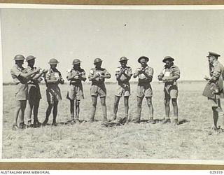 FORBES, AUSTRALIA. 1943-02. "GUINEA PIGS" TAKING PART IN A GAS SHELL EXPERIMENT HELD BY 2/1 AUSTRALIAN CHEMICAL WARFARE LABORATORY, APPLYING PROTECTIVE OINTMENT TO ONE ARM ONLY, LEAVING THE OTHER ..