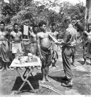 WASU, PAPUA, 1944-03-25. VX139850 WARRANT OFFICER CLASS 2 R. N. BEETHAM (1), AUSTRALIAN NEW GUINEA ADMINISTRATIVE UNIT OF THE MEDICAL SECTION, GIVING INTRAVENOUS INJECTIONS TO NATIVES WHO ARE BEING ..