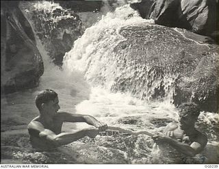 NEW GUINEA. C. 1943-12. TWO RAAF AIRMEN ENJOY A SWIM IN A MOUNTAIN STREAM IN THE JUNGLE