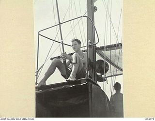 AT SEA. 1944-06-24. ABLE SEAMAN NORTON, ROYAL AUSTRALIAN NAVY, DOING HIS TURN AT "LOOKOUT" DUTY ABOARD THE FAIRMILE ML431 (MOTOR LAUNCH) AS THE VESSEL PATROLS ALONG THE COAST BETWEEN HANSA BAY AND ..