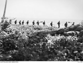 MADANG, NEW GUINEA. 1944-04-26. A PATROL FROM C COMPANY, 57/60TH INFANTRY BATTALION, SILHOUETTED AGAINST THE OCEAN AS THEY WALK ALONG THE BEACH AFTER CROSSING THE GOGOL RIVER 5 MILES FROM MADANG. ..