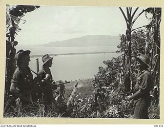 KARAWOP, AITAPE-WEWAK SECTOR, NEW GUINEA. 1945-04-29. PERSONNEL OF A COMPANY, 2/1 INFANTRY BATTALION, AT A POINT OVERLOOKING KARAWOP, PARIS ISLAND (LONG AND FLAT), AND KAIRIRU ISLAND (HIGH AND ..