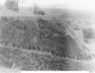 KAIAPIT, NEW GUINEA, 1943-09-22. TROOPS OF THE 2/27TH AUSTRALIAN INFANTRY BATTALION MOVING UP A STEEP HILL TO TAKE UP A POSITION OVERLOOKING THE VILLAGE