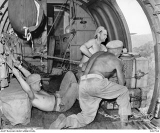 To shove loads of supplies out of a RAAF Douglas C47 Dakota transport aircraft, widely known as the biscuit bomber, Private Ted Rowell of Sydney, NSW, lies on his back and doubles his legs behind ..