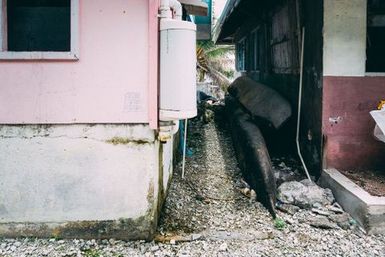 Canoes between two buildings, Fakaofo, Tokelau