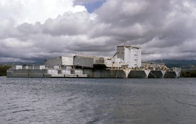 A view of several mothballed service vessels at anchor near Beckoning Point in the Middle Loch. Included are refrigerated covered lighters (YFRNs) and floating drydocks