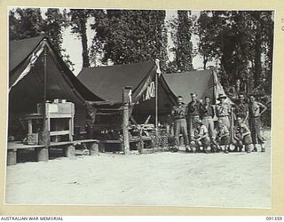 TOROKINA, SOUTH BOUGAINVILLE. 1945-04-28. A GROUP TAKEN IN THE CAMP LINES AND SHOWING THE BRANCH ORDERLY ROOM AT THE TRANSPORT AND LIGHT AID DETACHMENT SECTION ATTACHED HEADQUARTERS 2 CORPS