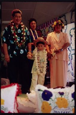 Kayne Lucas Upokokeu is escorted around the hall by his grandparents during his hair-cutting ceremony