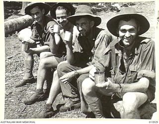 1942-12-23. PAPUA. SOPUTA. FOUR AUSTRALIANS DRINK A CUP OF COFFEE AT A SALVATION ARMY HUT. LEFT TO RIGHT - PTES. R.D. MILLER, O. NAGLE, L.G. BRAUND OF N.S.W. AND H. JOHANSEN OF QUEENSLAND. THE ..