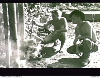 THE SOLOMON ISLANDS, 1945-02-26. CLOTHES WASHING DAY FOR TWO AUSTRALIAN SERVICEMEN AT THEIR CAMP ON BOUGAINVILLE ISLAND. (RNZAF OFFICIAL PHOTOGRAPH.)