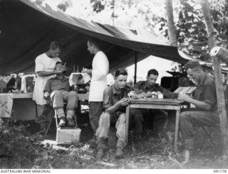 KARAWOP AREA, NEW GUINEA. 1945-04-20. 2/3 DENTAL UNIT TREATING MEMBERS OF 2/1 INFANTRY BATTALION THIS IS THE FIRST TIME IN ANY CAMPAIGN THAT A DENTAL UNIT WAS UP WITH A FORWARD BATTALION WORKING ..