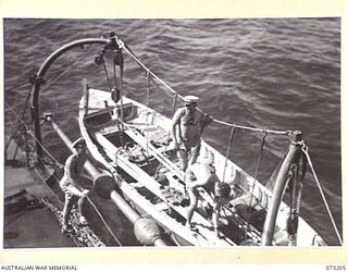 OFF MADANG, NEW GUINEA. 1944-05-14. MEMBERS OF THE CREW ABOARD THE RAN FRIGATE HMAS BARCOO PREPARE TO LOWER THE TENDER. THE VESSEL HAS RETURNED FROM AN ACTIVE PATROL NORTH OF MADANG
