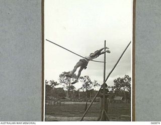 NEW GUINEA. 1943-11-20. PRIVATE A. W. MCPHERSON, 2/10TH AUSTRALIAN INFANTRY BATTALION, CLEARING THE BAR AT EIGHT FEET AND EIGHT INCHES IN THE POLE VAULT AT THE SPORTS MEETING ORGANISED BY THE 18TH ..