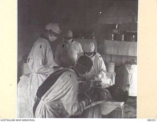 VX65677 CAPTAIN J.G. MCMAHON, 2/11TH GENERAL HOSPITAL, AUSTRALIAN ARMY MEDICAL CORPS, ASSISTED BY HIS THEATRE TEAM, OPERATES FOR SHRAPNEL ABDOMINAL WOUNDS. 86 OPERATIONS HAVE BEEN PERFORMED WITHIN ..
