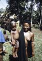 Papua New Guinea, woman carrying child in village