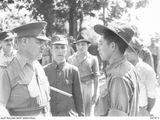 BLANCHE BAY, NEW BRITAIN. 1945-09-28. LIEUTENANT GENERAL J. NORTHCOTT, CHIEF OF GENERAL STAFF (1) CHATS WITH TIM MACH, A CHINESE CIVILIAN INTERPRETER WHO WAS INTERNED FOR THREE YEARS (4), DURING A ..