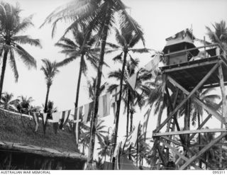 JACQUINOT BAY, NEW BRITAIN, 1945-08-15. THE LOOKOUT POST AT NAVY HEADQUARTERS IN THE PORT DIRECTORATE FLYING BUNTING WHEN NEWS OF THE ALLIED VICTORY CAME THROUGH