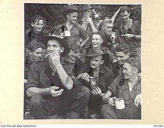 GAZELLE PENINSULA, NEW BRITAIN, 1945-05-15. TROOPS OF A COMPANY, 37/52 INFANTRY BATTALION, TAKING A PAUSE AFTER THEIR ARRIVAL AT THE BEACH ON THE NORTH COAST OF NEW BRITAIN AT THE END OF THEIR TREK ..