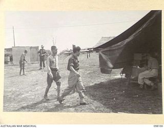 CAPE WOM, NEW GUINEA. 1945-10-19. LIEUTENANT TAZAKI, OF THE JAPANESE ARMY, BEING ESCORTED BY SERGEANT MAYO, ALLIED INTERPRETER US ARMY, TO THE TENT AT HEADQUARTERS 6 DIVISION, WHERE THE WEWAK WAR ..