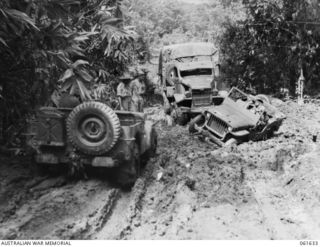NEW GUINEA. 1943-12-11. A JEEP ENDEAVOURING TO PULL ANOTHER OUT OF THE MUD ON THE GODOWA-BUTAWA CREEK ROAD