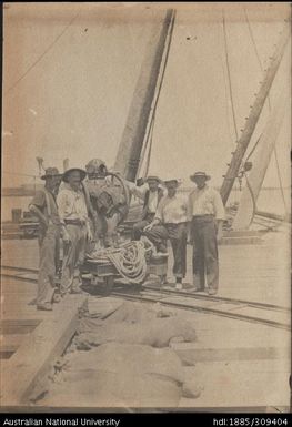 Men moving diving gear with a  rail cart at Lautoka wharf