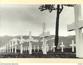 DUMPU, NEW GUINEA. 1944-01-25. NEAT WHITE CROSSES MARK THE GRAVES OF MEN WHO FELL IN THE MARKHAM AND RAMU VALLEY CAMPAIGNS. THE CEMETERY WILL ALSO BE THE BURIAL PLACE OF ALL MEN KILLED BETWEEN ..