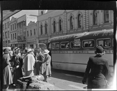 Unidentified group waiting at a Johnston's Airways Transport bus in Auckland at the beginning of White's Fiji tour