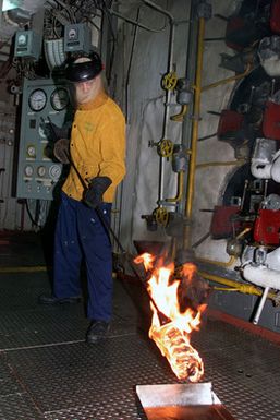 Machinist's Mate 3rd Class (MM3) Nicholas Leininger lights boiler #2 in the forward main machinery room aboard the amphibious assault ship USS SAIPAN (LHA 2)