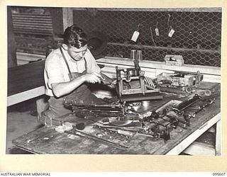 LAE AREA, NEW GUINEA. 1945-08-31. SERGEANT J.M. FOLEY OVERHAULING A MACHINE IN THE TYPEWRITER REPAIR WORKSHOP, 9 LINES OF COMMUNICATION STATIONERY DEPOT