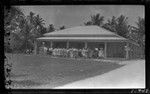 Men, women and children standing in front of building