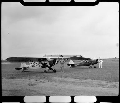 Corporal W Tarr and T French with airplanes at Nausori Airport, Fiji