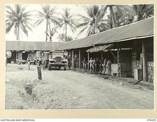 LAE, NEW GUINEA. 1944-10-04. UNIT TRUCKS DRAWING GOODS AT THE ISSUING STORE OF THE AUSTRALIAN ARMY CANTEENS SERVICE BULK STORE, NEW GUINEA DETACHMENT